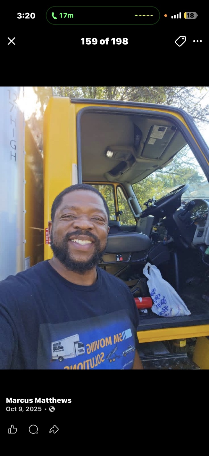 A 5M team member beside the yellow moving truck