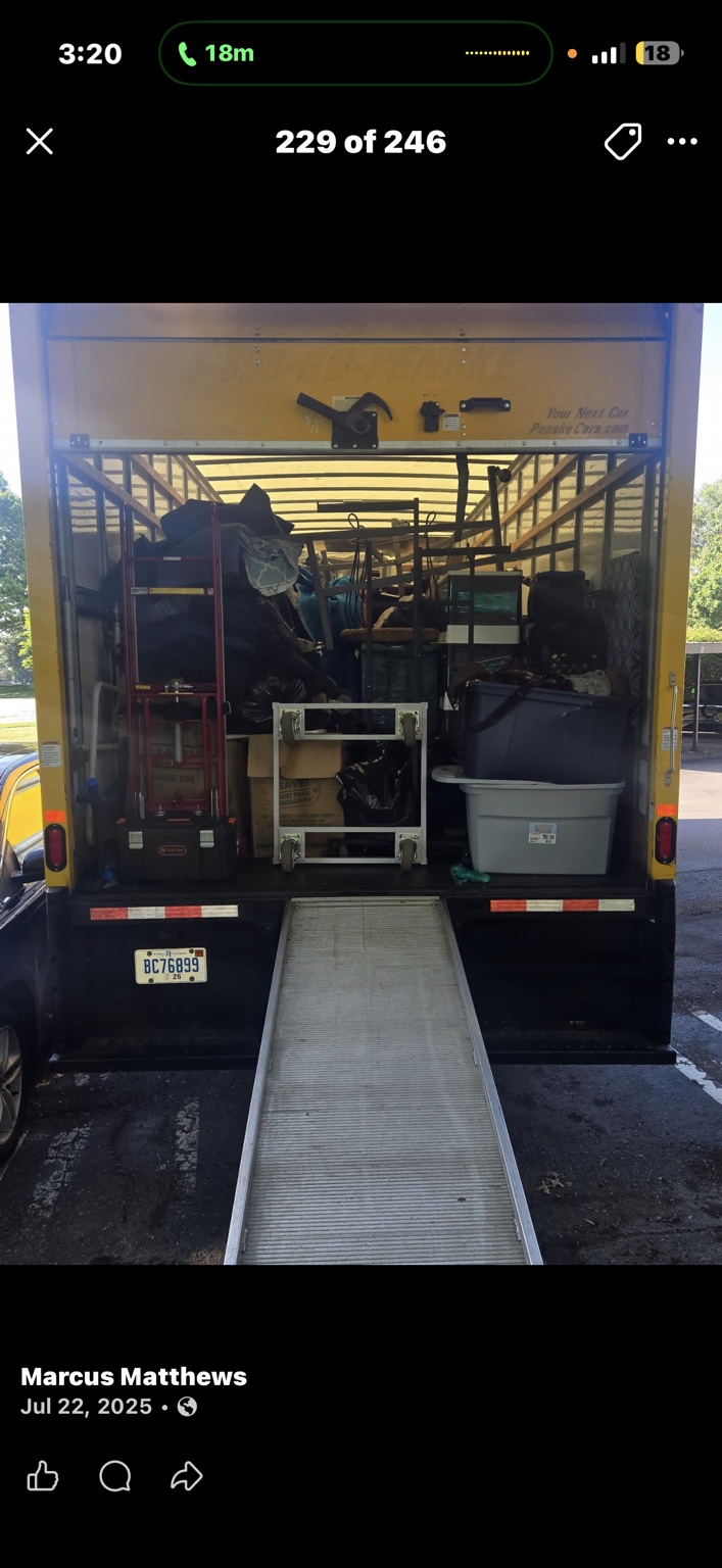 A loaded yellow moving truck with its ramp extended